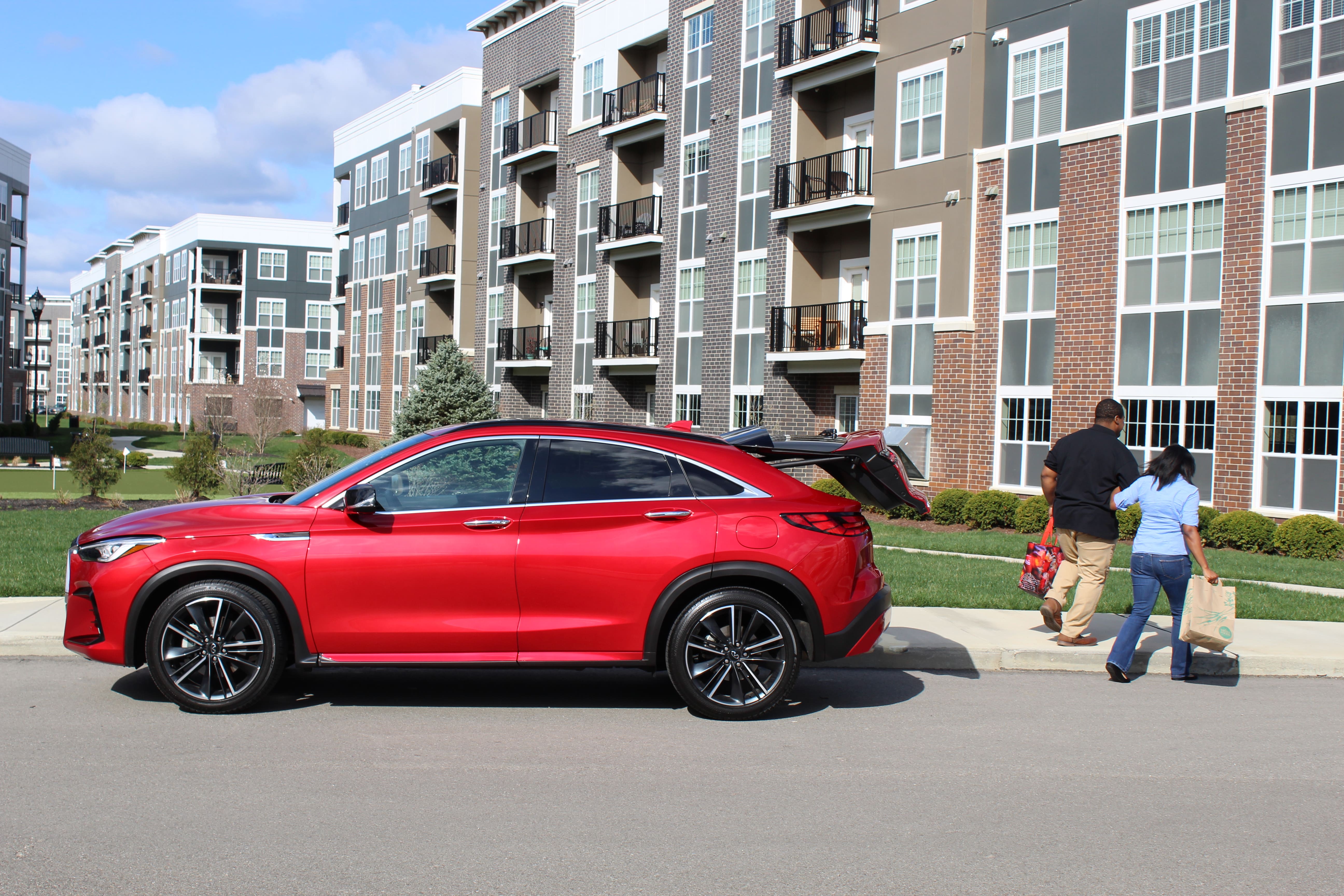 A couple walsk from their red INFINITI QX55 to their home