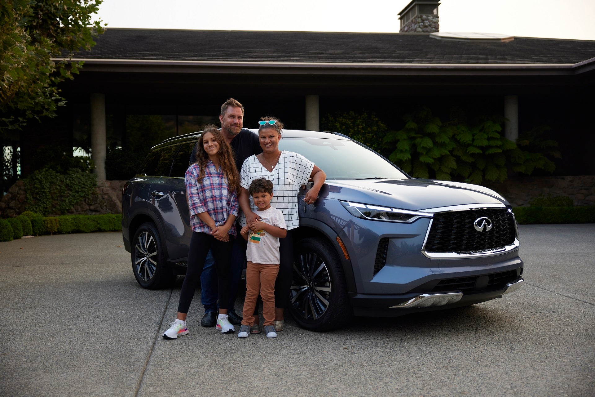 A family stands by their new INFINITI vehicle